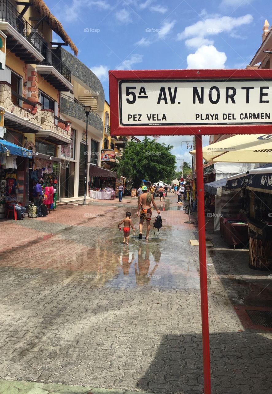 A father and son returning home after a day of swimming. 