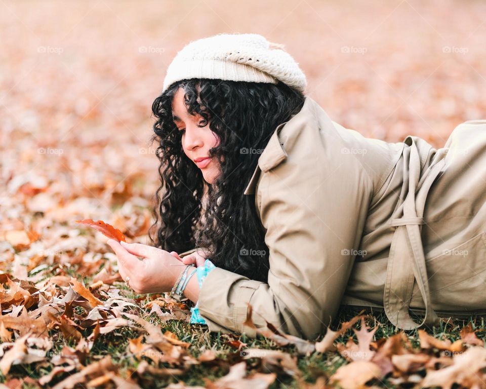 Woman, Laying down on colorful fall leafs. 