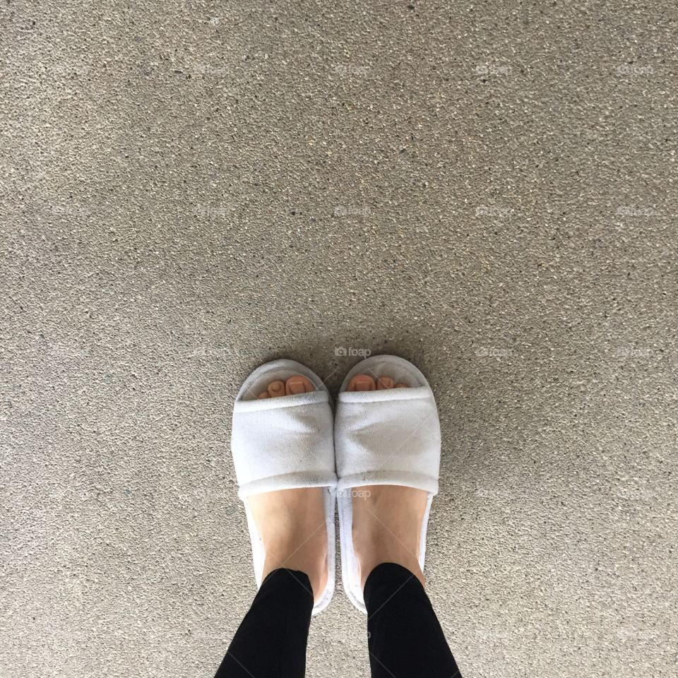 Close up of a woman's white Fluffy slippers standing great for any use.