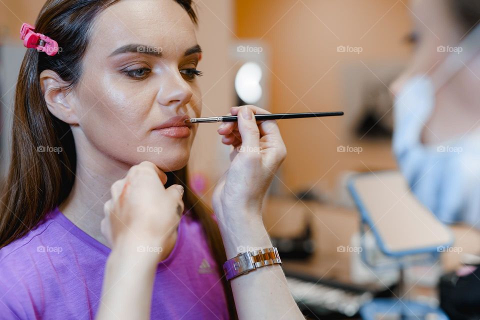 Makeup artist at work.  Applying makeup to a woman.  Professional cosmetics