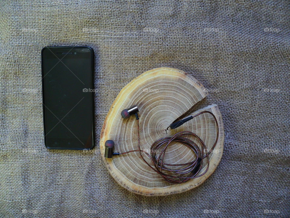 vacuum headphones and smartphone on the cut of a cut tree