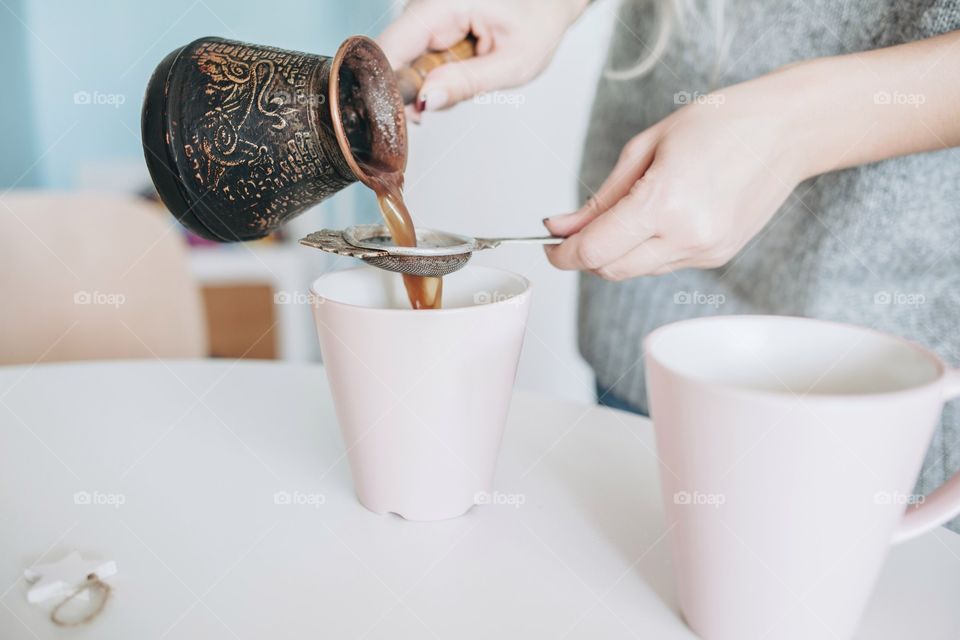 Woman's hand pouring tea in cup