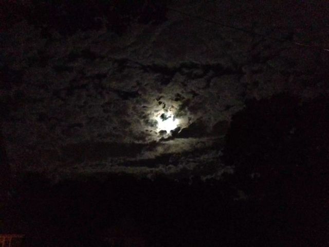Eerily shaped clouds gathering around the full moon.