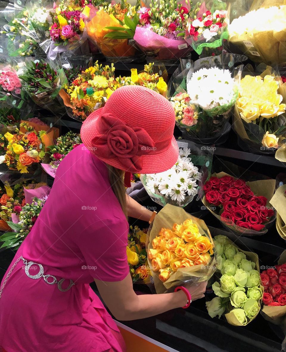 Women in bright pink selecting roses.