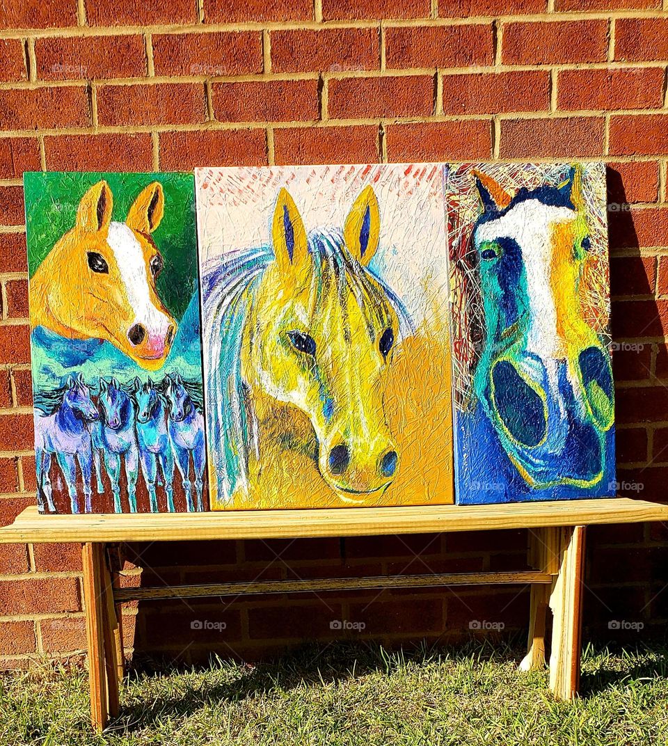 pinturas varias de caballos en un banquillo,arte moderno