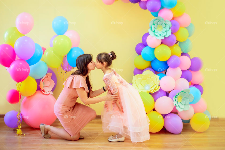Mother with daughter in colorful balloons 