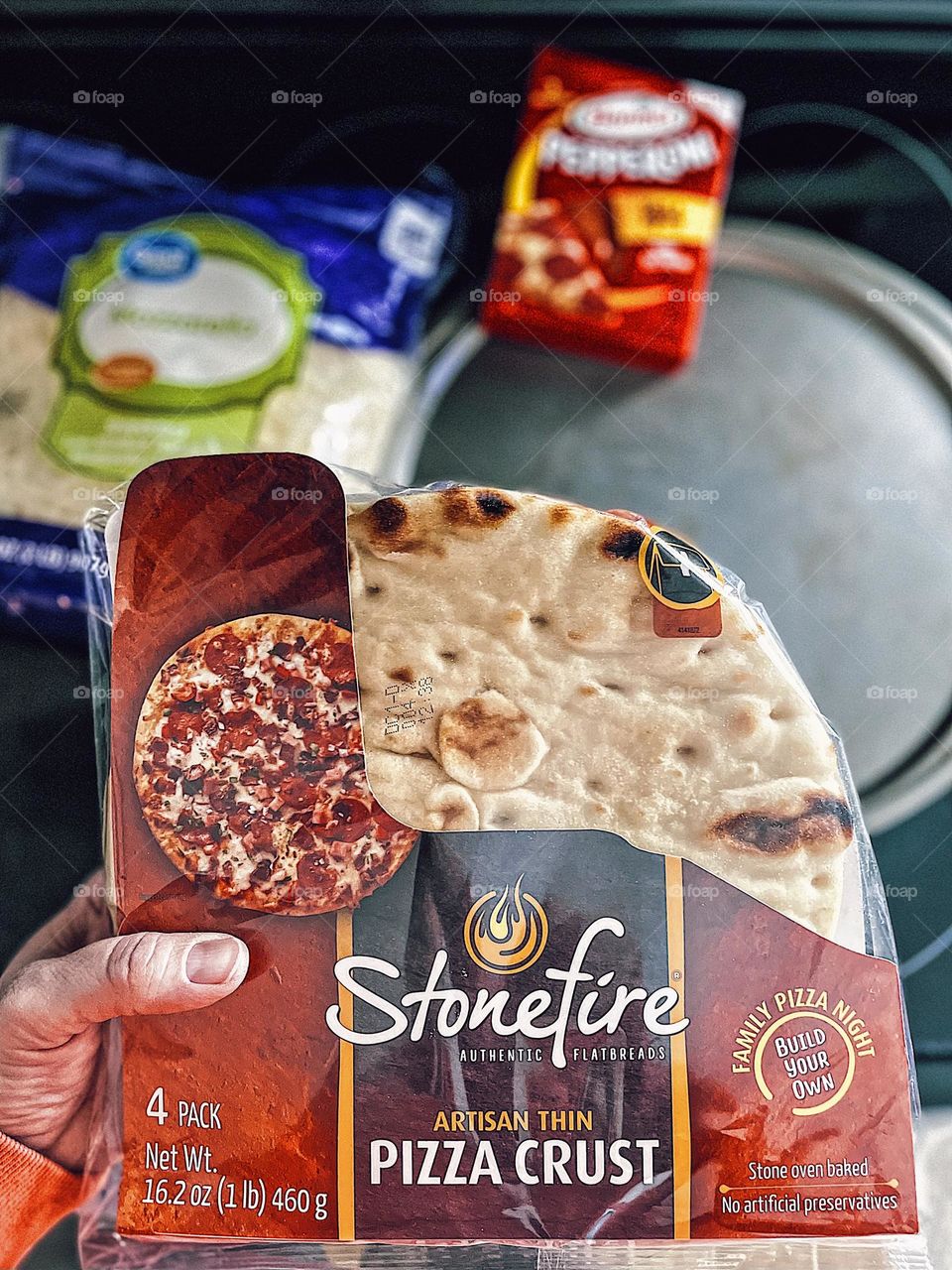 Making a homemade pizza, Stonefire pizza crusts and Hormel pepperoni, making dinner at home, family time at home, woman’s hand holding pizza ingredients, woman’s hand makes dinner, mommy makes dinner for the family, making pizza at home