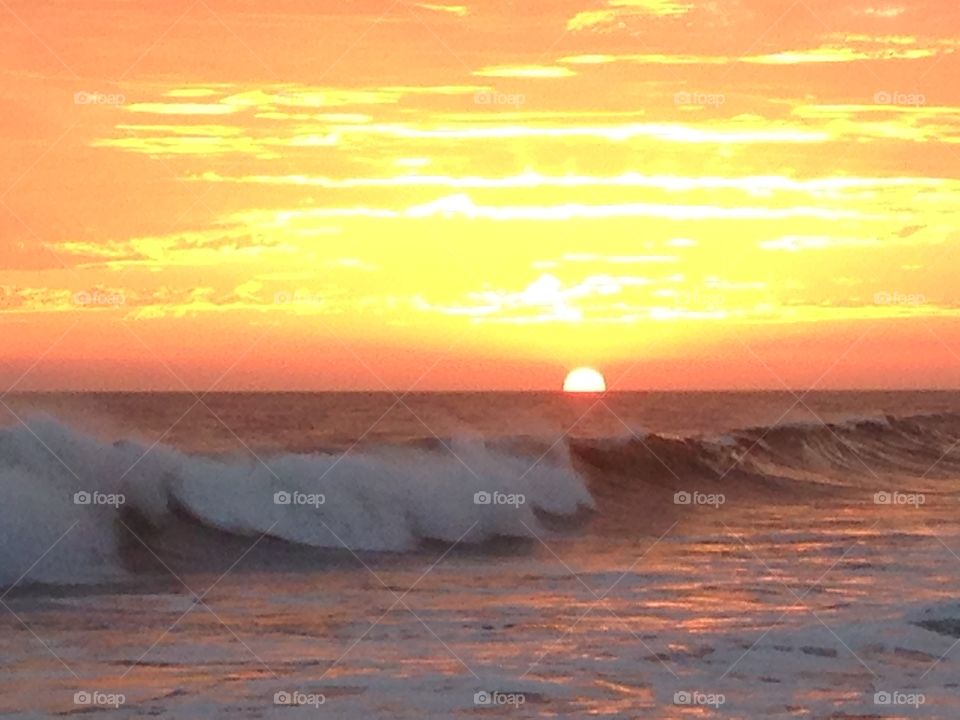 Apricot sunset and rolling waves on Huntington Beach
