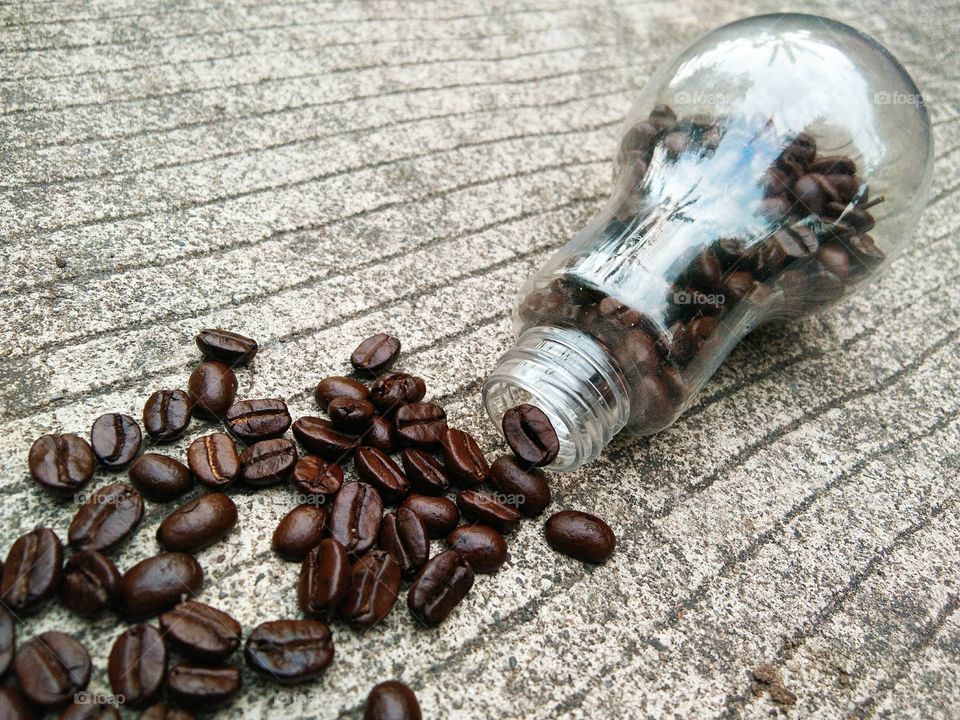 coffee beans in glass bottle on concrete floor