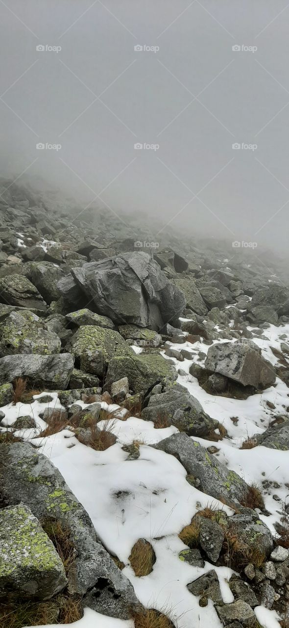 Rocky hills with snow and mist panorama