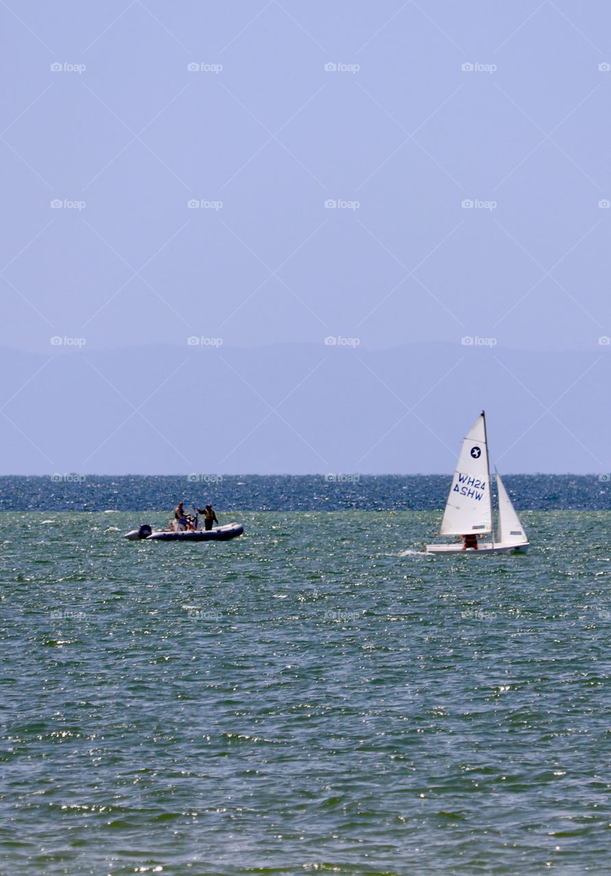 Sailboat race at sea, with zodiac style rubber lifeboat following 