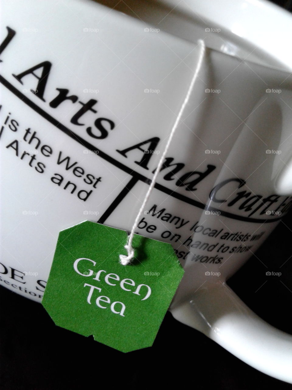 Green tea in a black and white newspaper cup