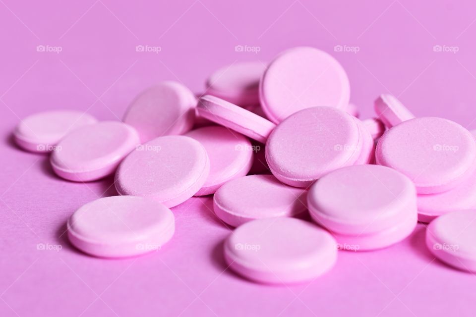 Pink tablets on a pink background 