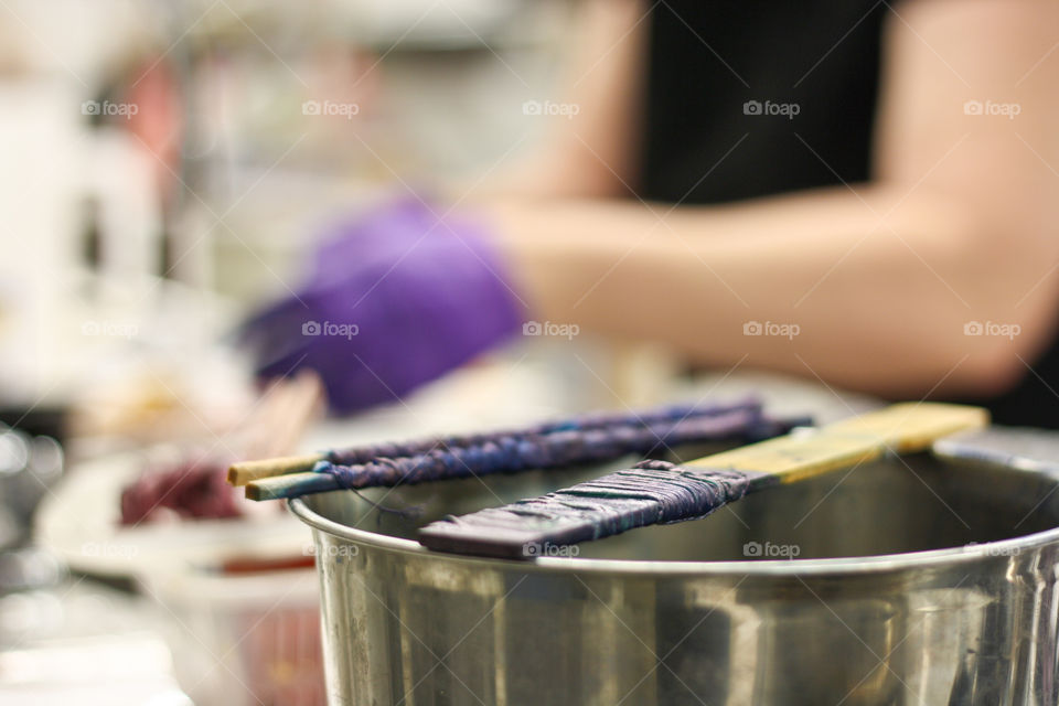 Newly dyed pieces of fabric wait to be washed while the artist works in the background 