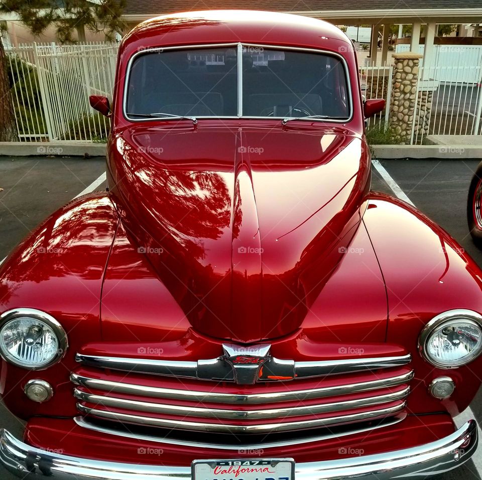 A beautifully restored 1947 pickup truck wears a resplendent coat of deep red to magenta paint