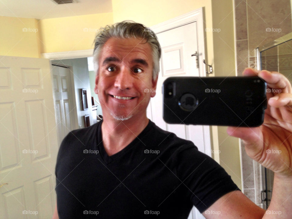 Selfie. Man doing a self portrait in front of mirror 