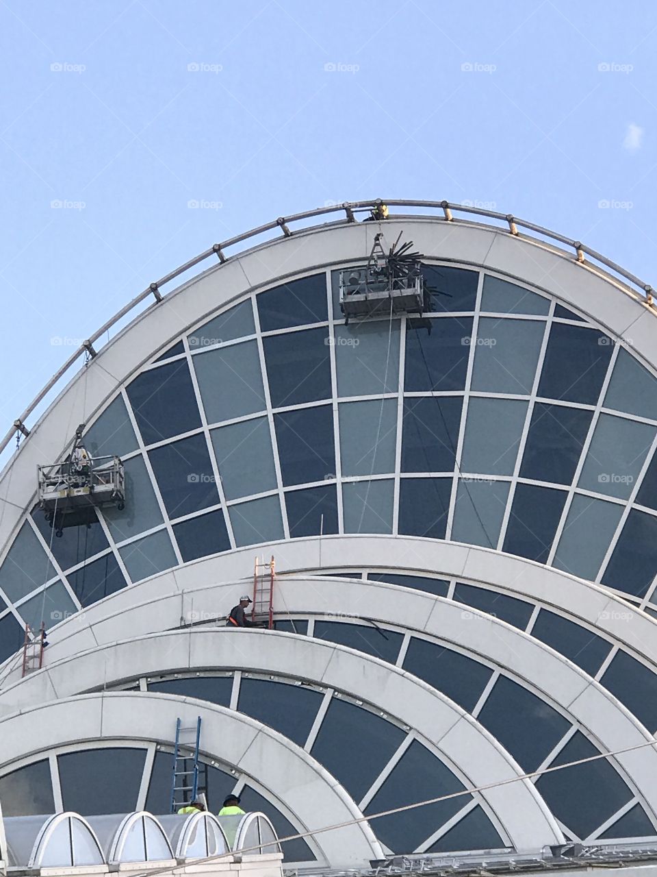 Several window washers  cleaning the North Course, of the Orange County Convention Center.  #occc