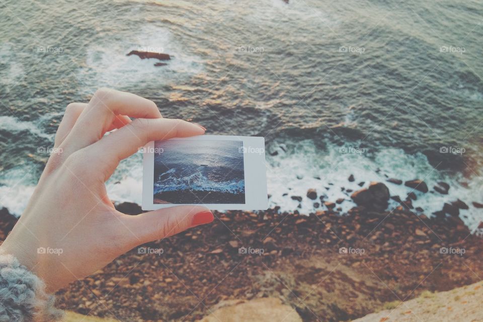 Awesome Atlantic Ocean. Sand beach and hand take a Polaroid shoot