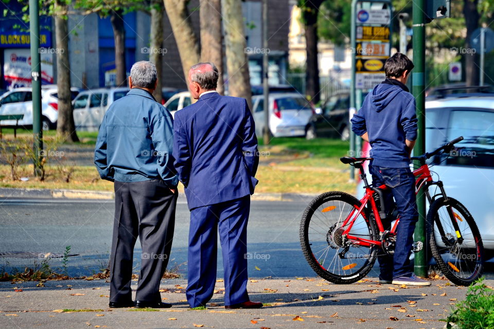 two older men standing chatting in the street