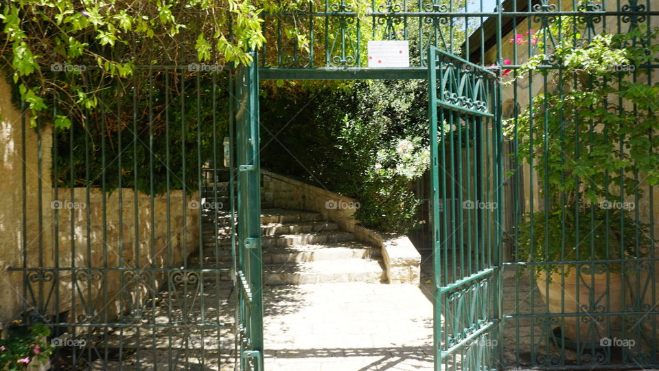 An open gate leading into a set of stairs