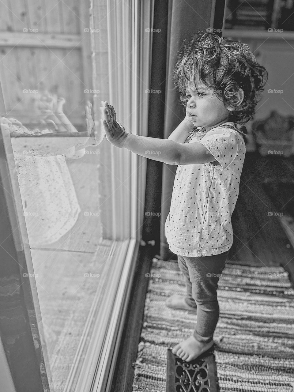 Toddler girl looking outside, toddler girl standing at window looking at reflection, portrait with reflection, monochrome portrait of young girl, family lifestyle portrait, curly haired girl profile portrait, portrait of a young person, reflecting 