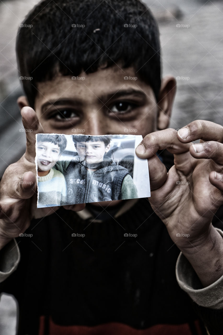Close-up of a boy showing photograph