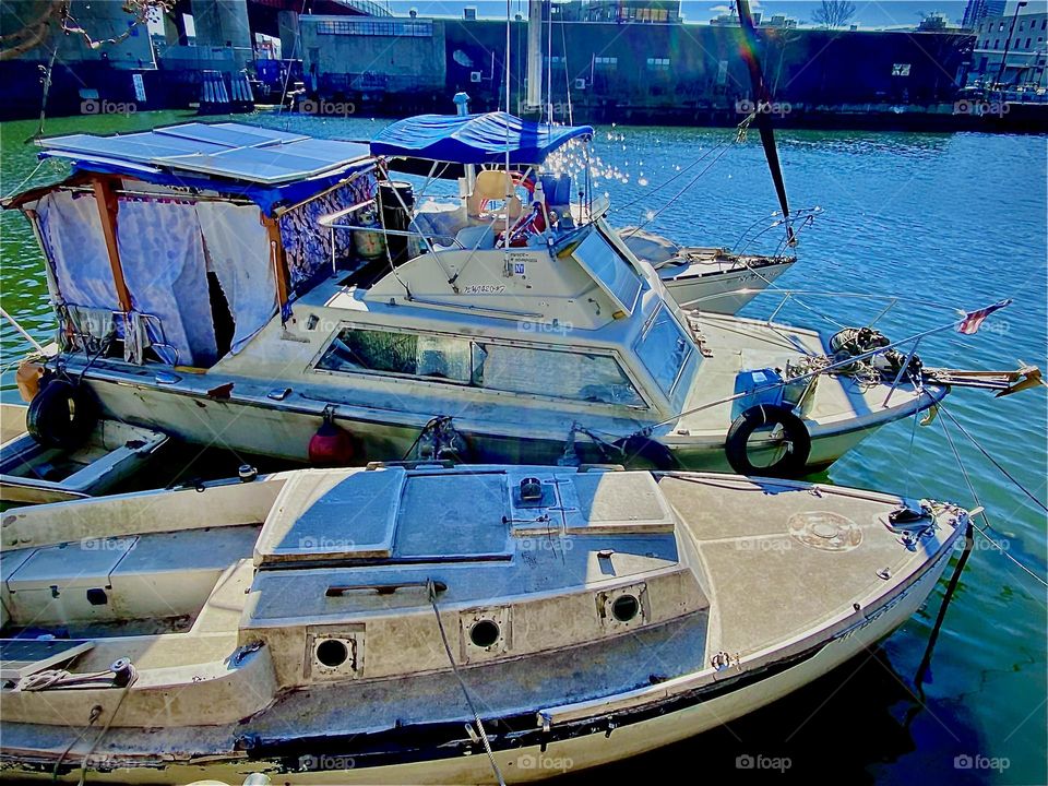 Our houseboat, the “Salvation” with multiple solar panels on the rooftop Timothy built over the back deck at Newtown Creek in LIC, Queens, NY. The cabin where we live is in the front. 2022. Hypnotic Productions