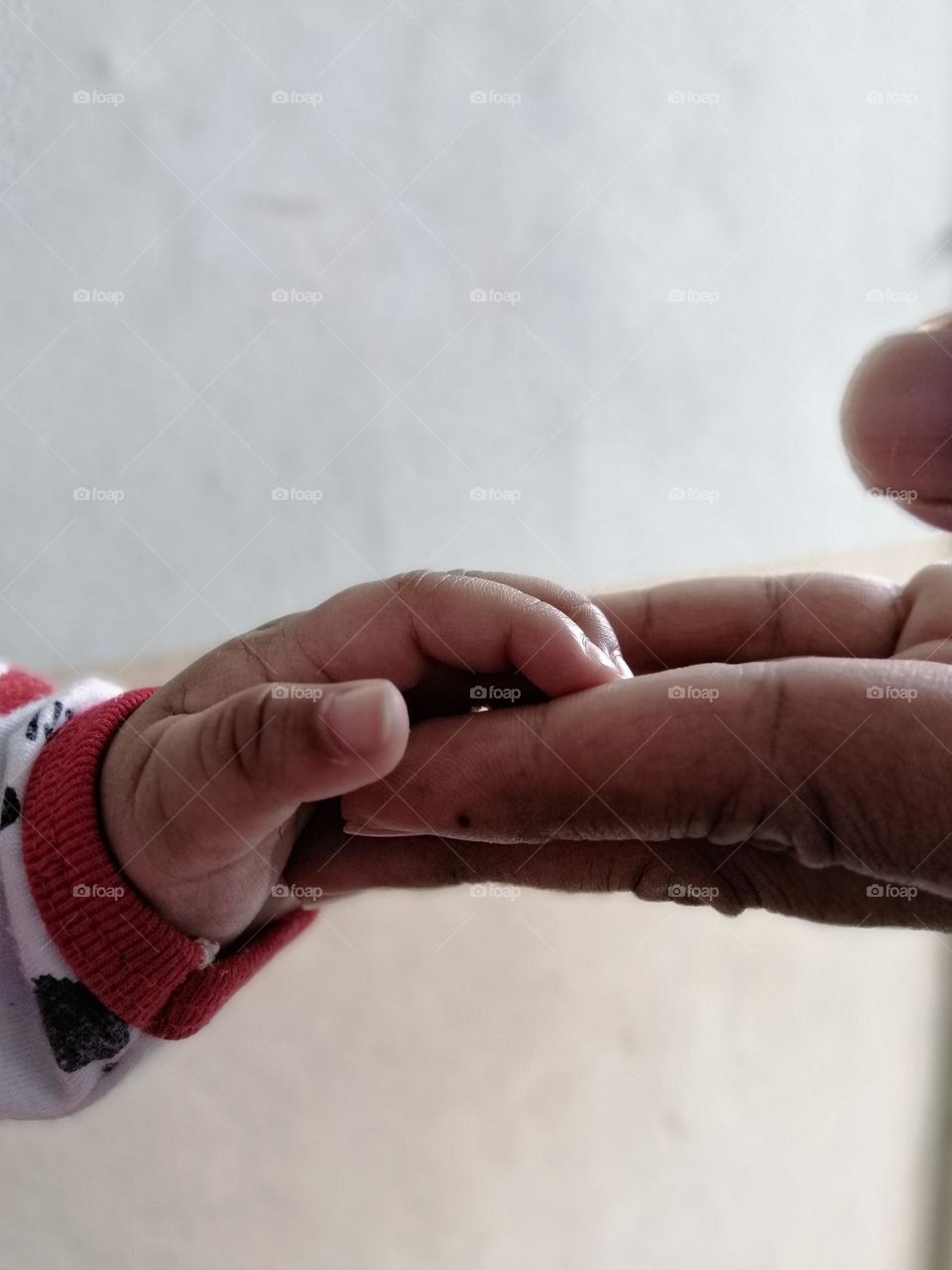 tiny little finger with daddy's hand