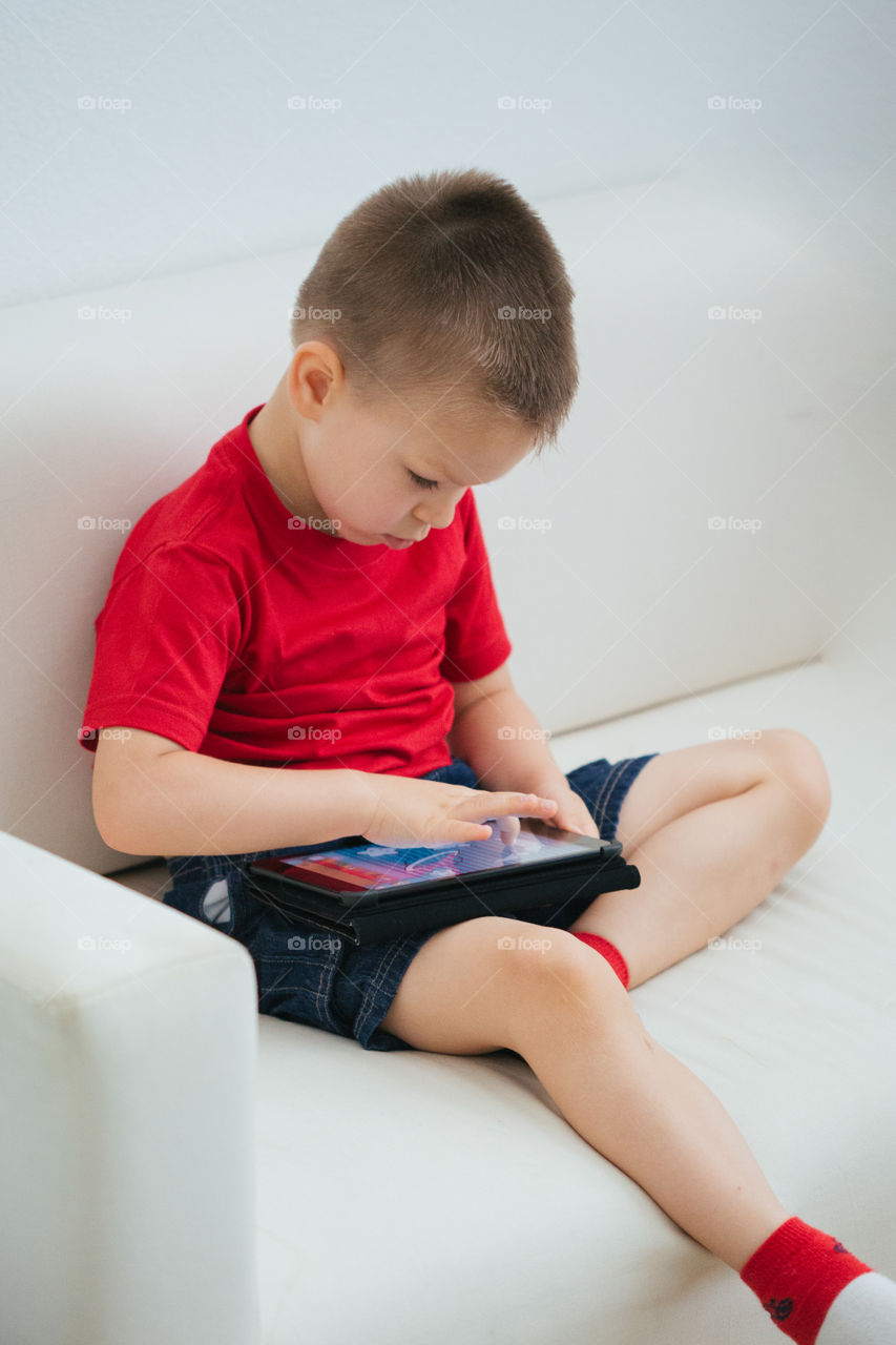 Toddler boy on tablet playing games 