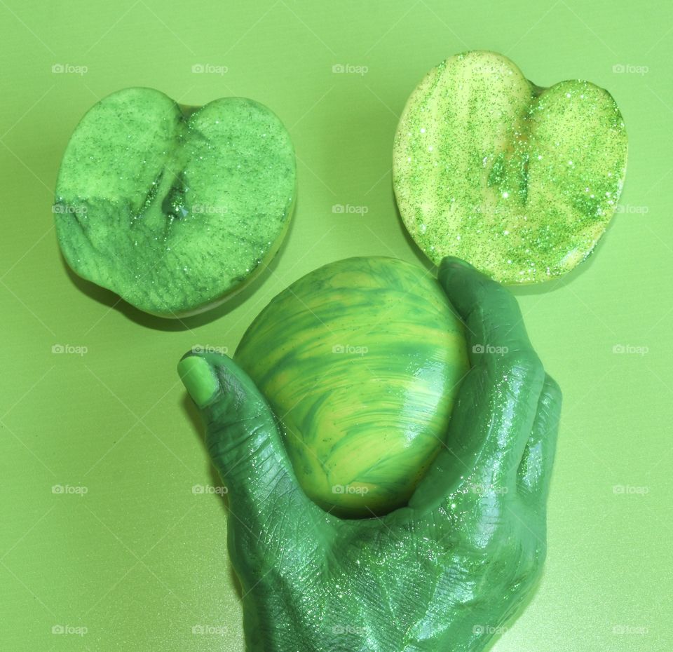 Green monochrome still life with apples and hand