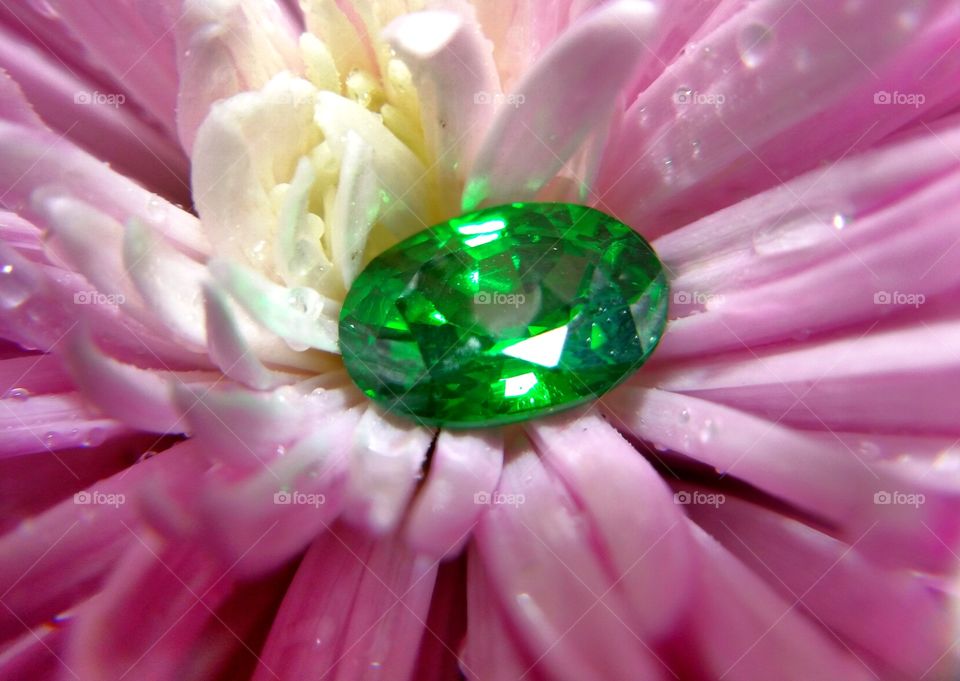 Small green emerald in pink petals 
