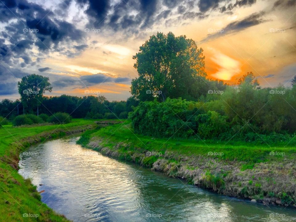 Colorful and dramatic sky over a river landscape at sunset