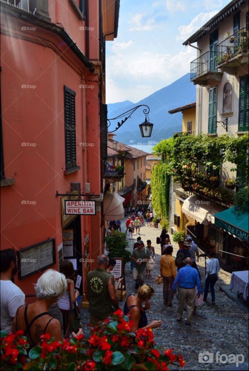 Summer day in Bellagio (Italy): a fresh breeze coming from the near lake embraced by the mountains, shirts and tops and flip flops all over, tan skins and smell of sun cream mixing with coffee lips and backed bread flavor in the alley.