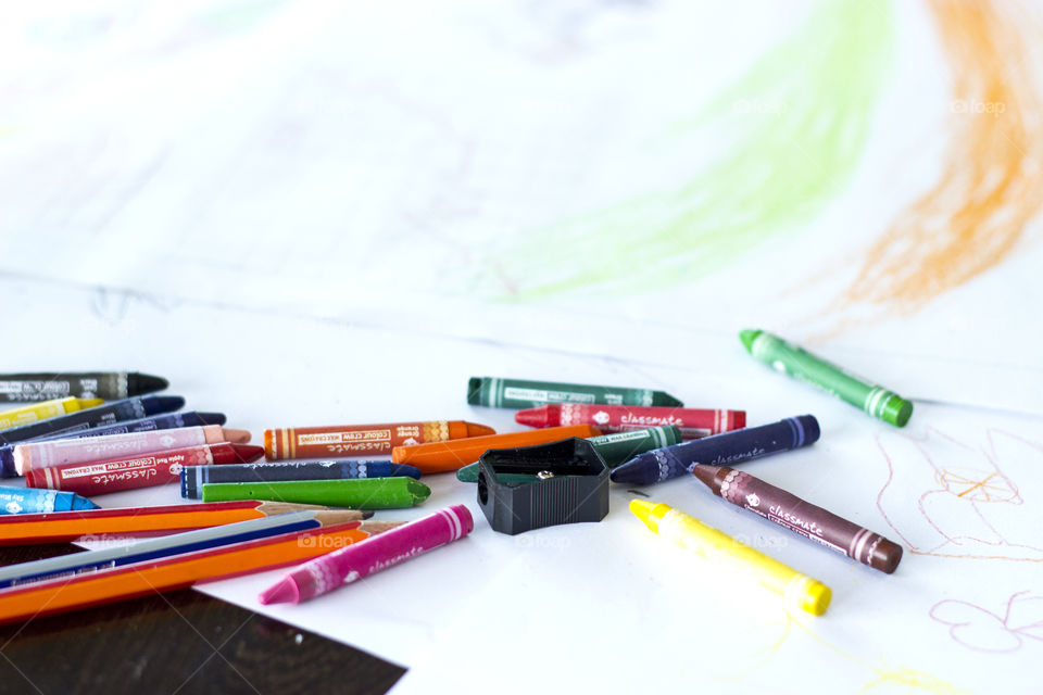 Colorful crayons on white sheet