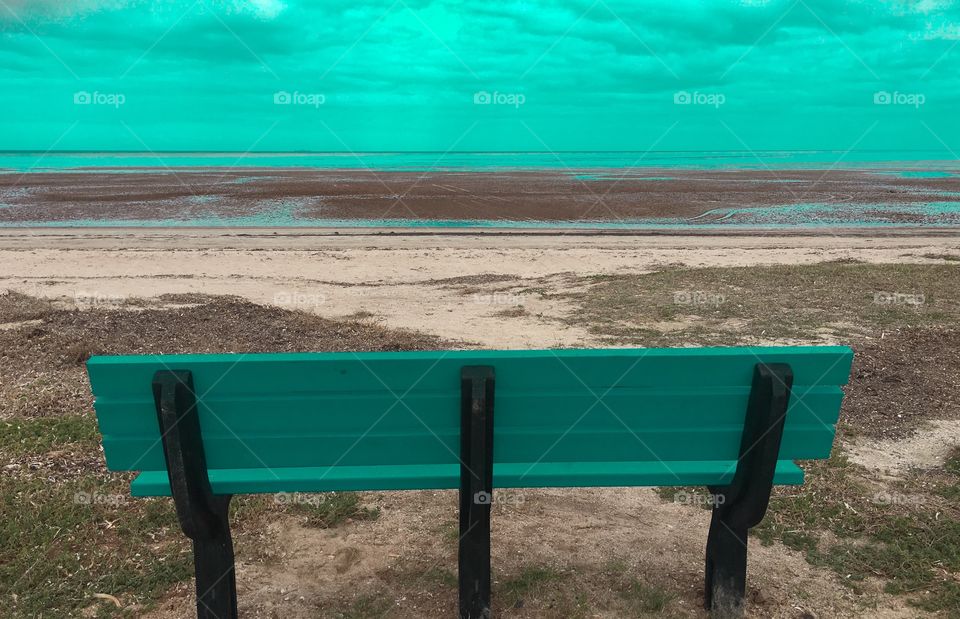 Aqua teal colours bench on remote tropical beach  room for text