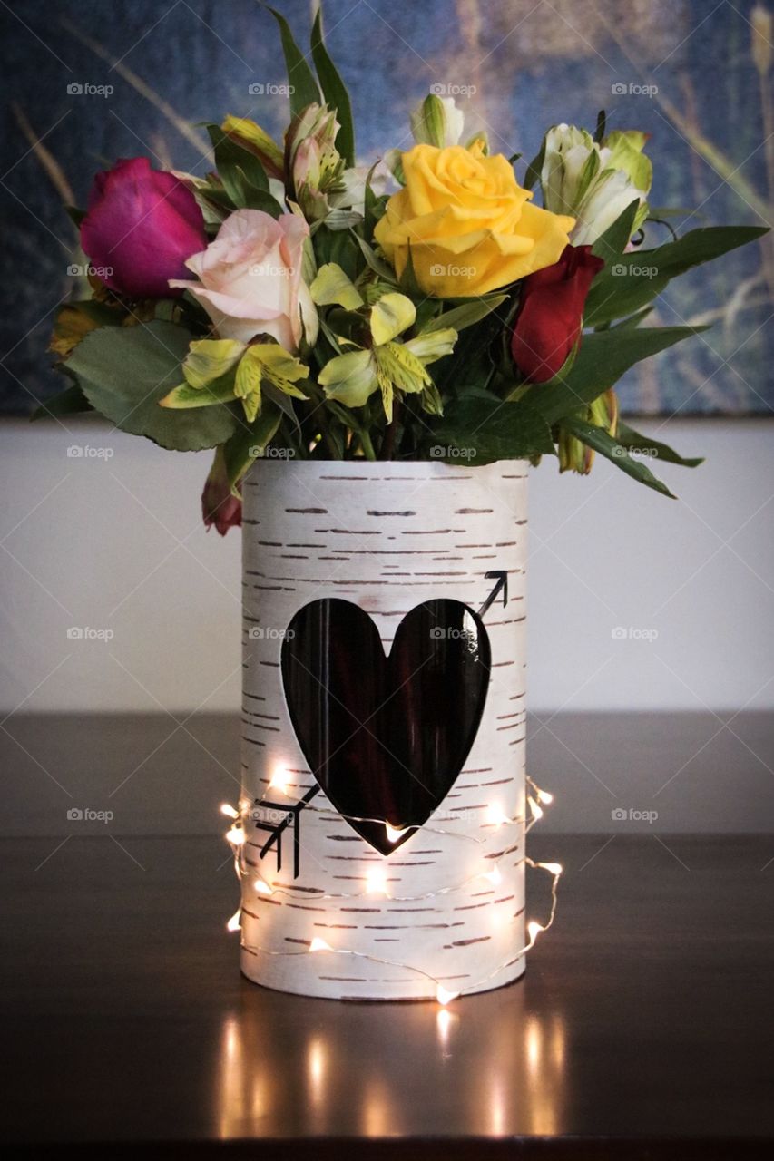 Bouquet of flowers in an aspen tree trunk vase with a heart. 