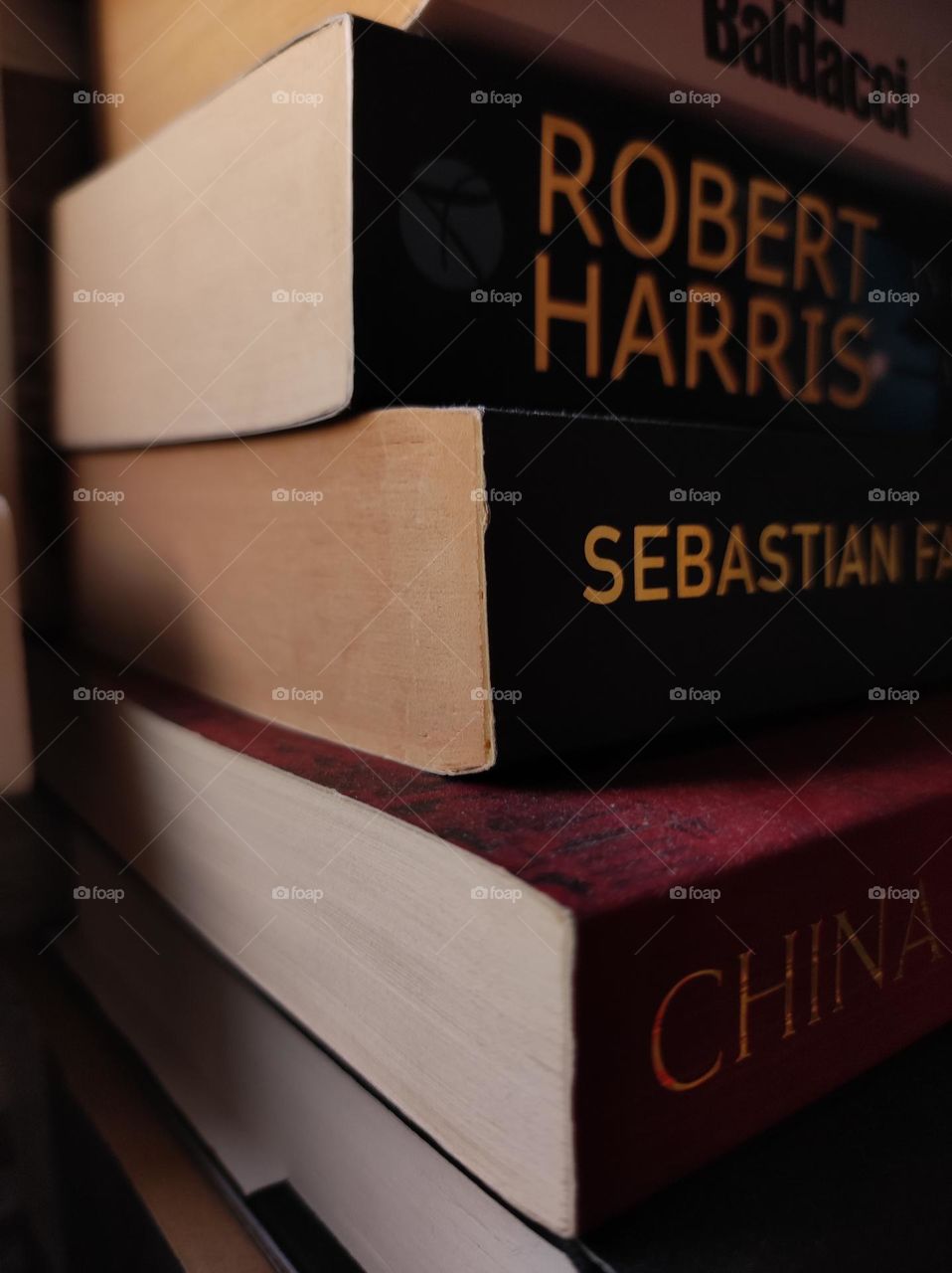 A close up photo of old beautiful books on a shelf in the morning light