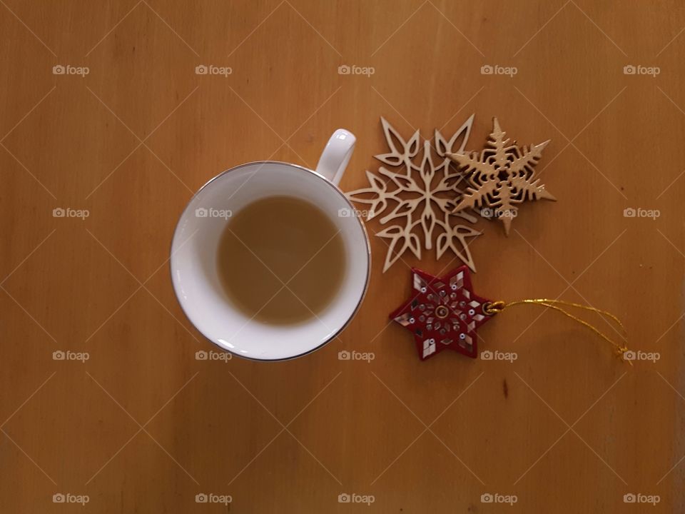 Warm beverage beside a few winter decorations.