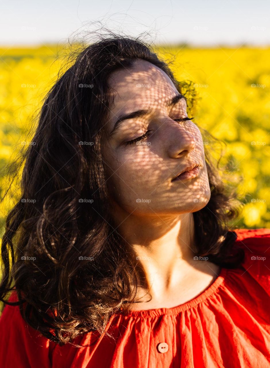 Millennial woman with beautiful brown hair, enjoying the nature in summer.