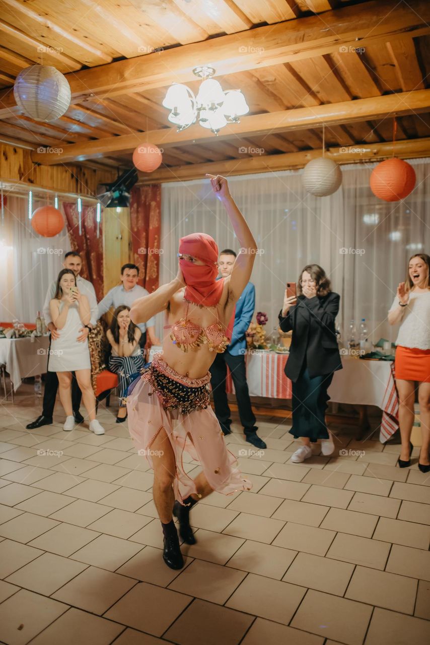 a boy disguised as a woman dances during a wedding