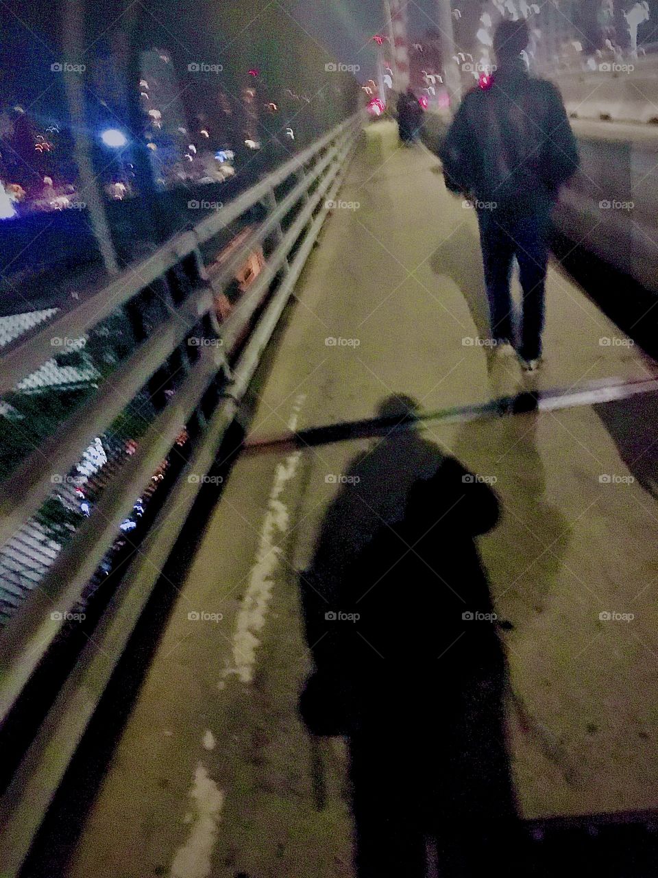 A pedestrian walks away visible only by his outline and my shadow seems to follow him as I’m taking this picture in October 2020 on the pedestrian lane of the Pulaski Bridge that connects Greenpoint, Brooklyn and Long Island City, Queens, NY. Hypn Pr