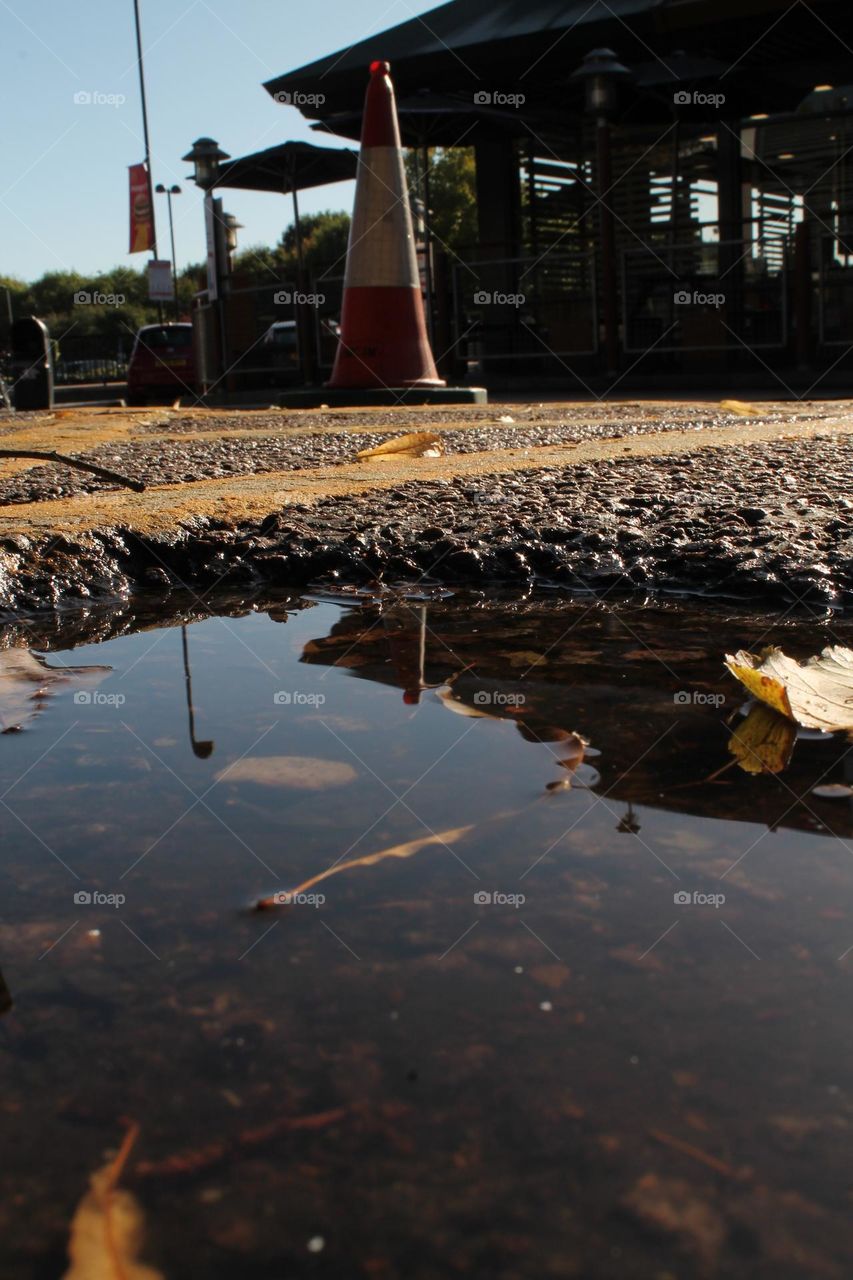 Puddle as a foreground, while a cone and part of McDonalds are in the background