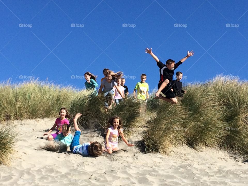 Sand Dune Jumping. Kids jumping on sand dune