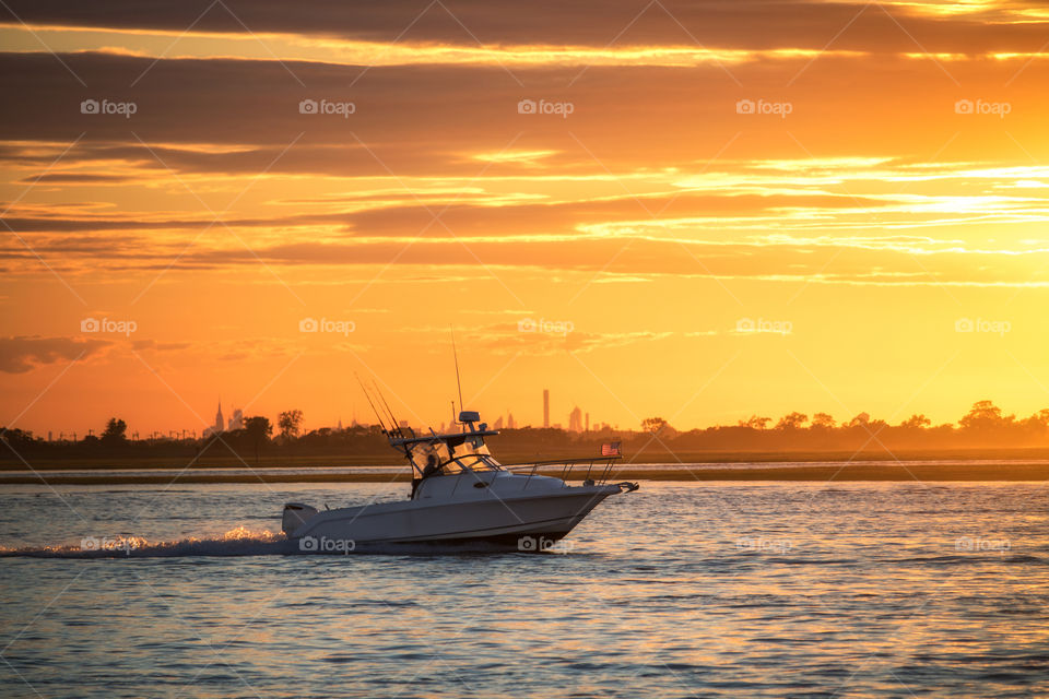 Fishing boat sailing home under a vibrant sunset after a long day on the water. 