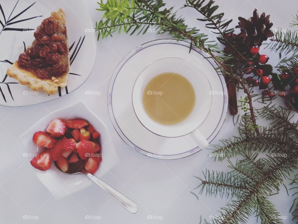 Cup of mint tea, bowl of strawberries and pecan pie
