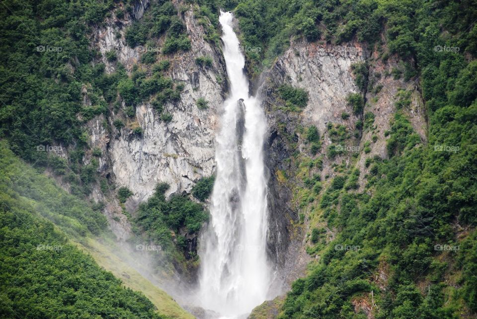 Melting water rushing down mountain from glacier