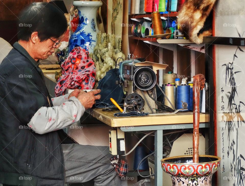 Chinese Artisan Crafting Textiles In A Workshop. Artisan Crafting Textiles
