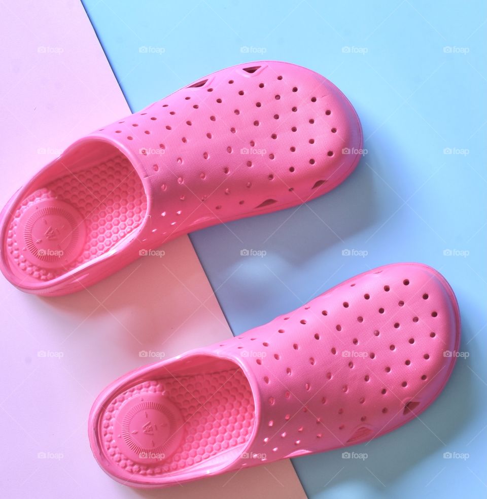 Pink water shoes on pink and blue background, still life, flat lay