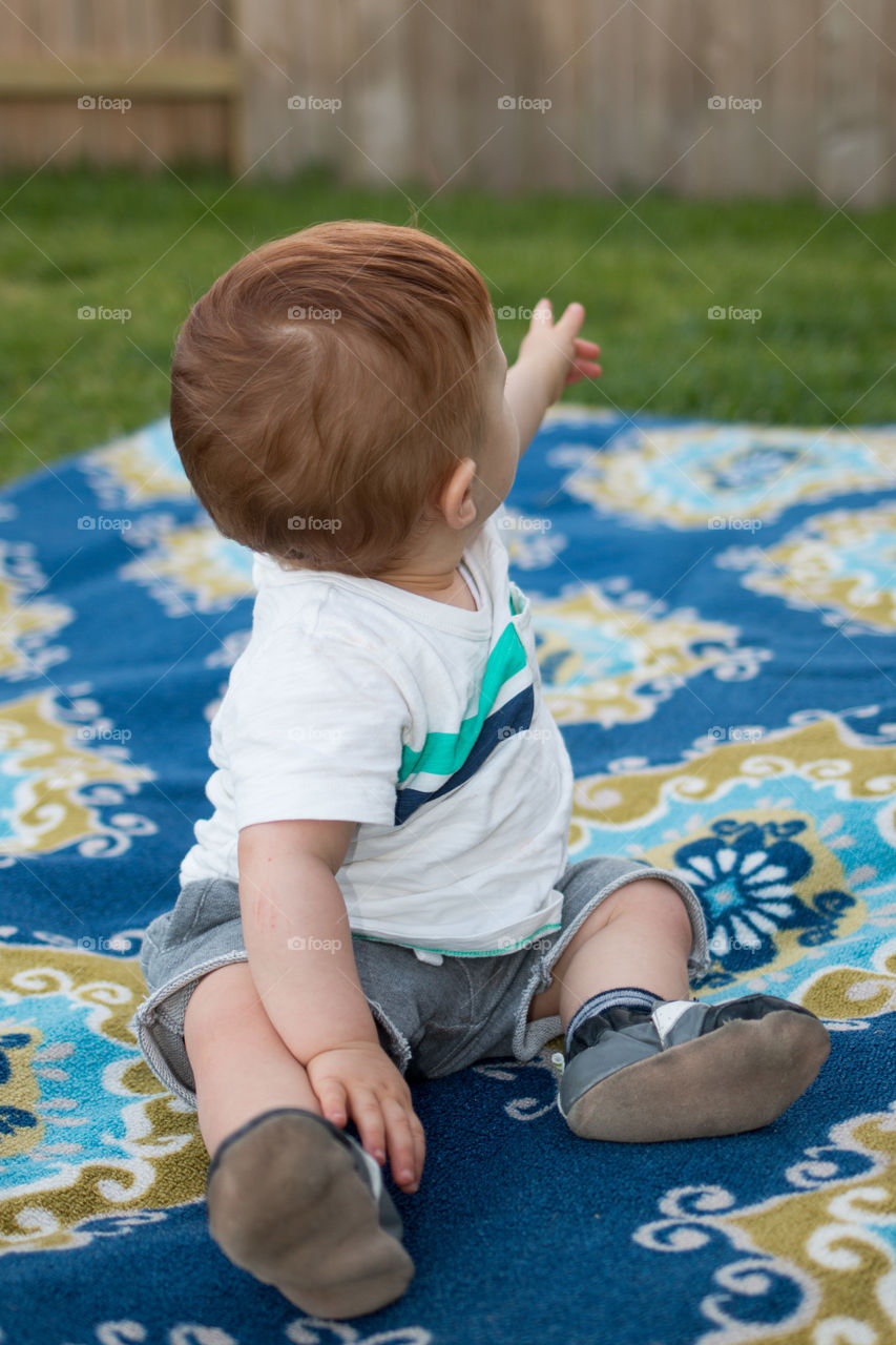 Baby boy sitting in garden