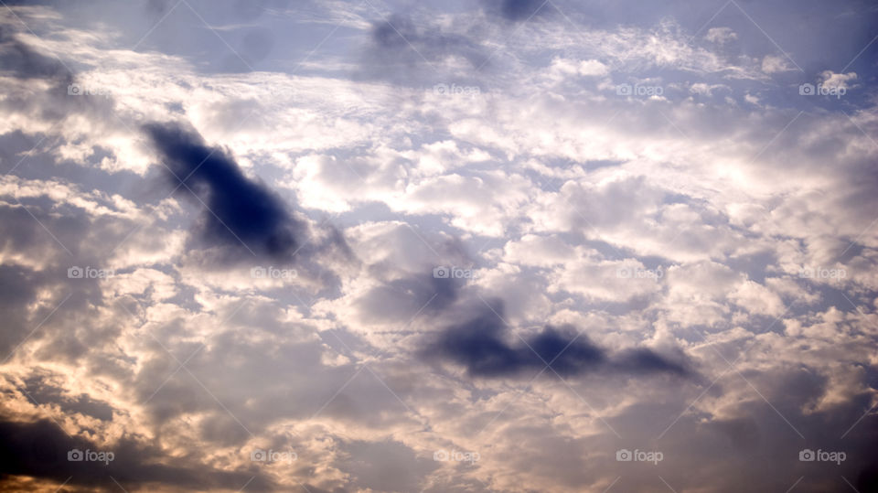 Light sky with three shades of wandering clouds.